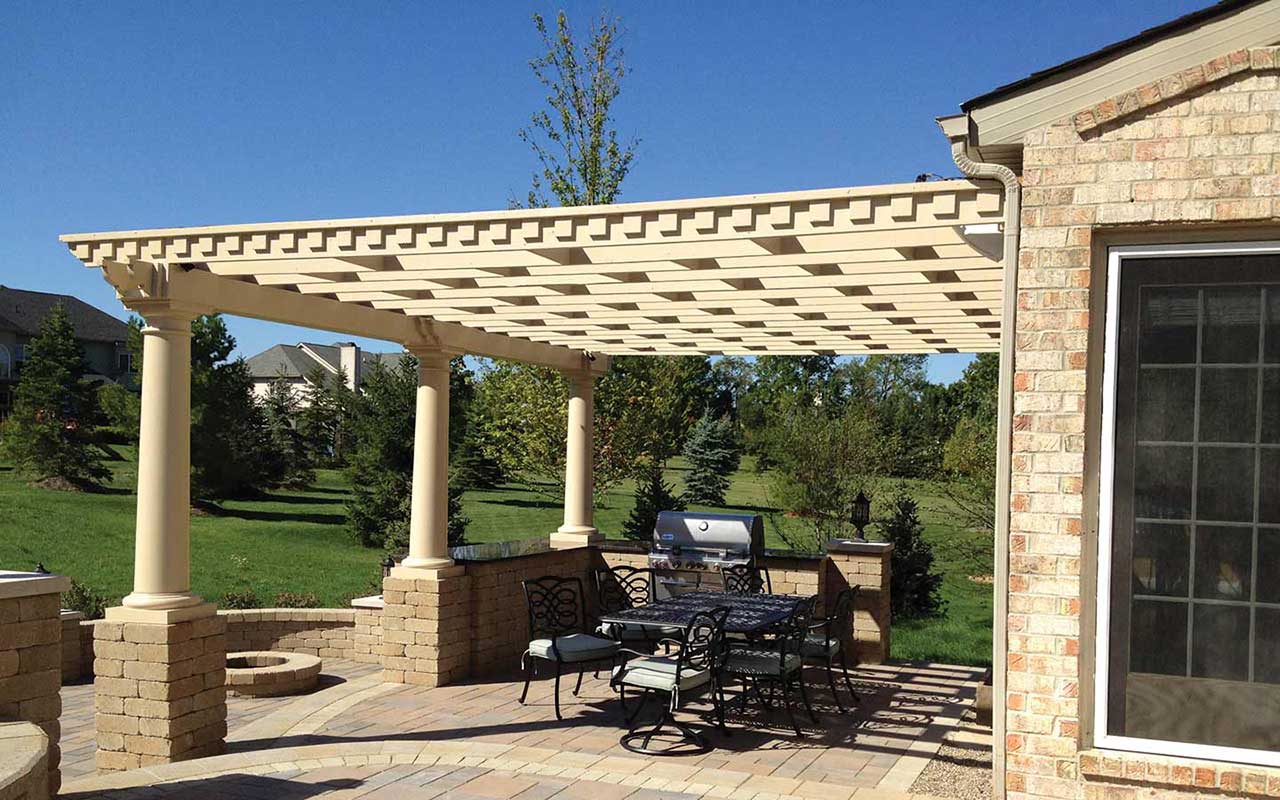a pergola over a patio with a table and chairs underneath it .