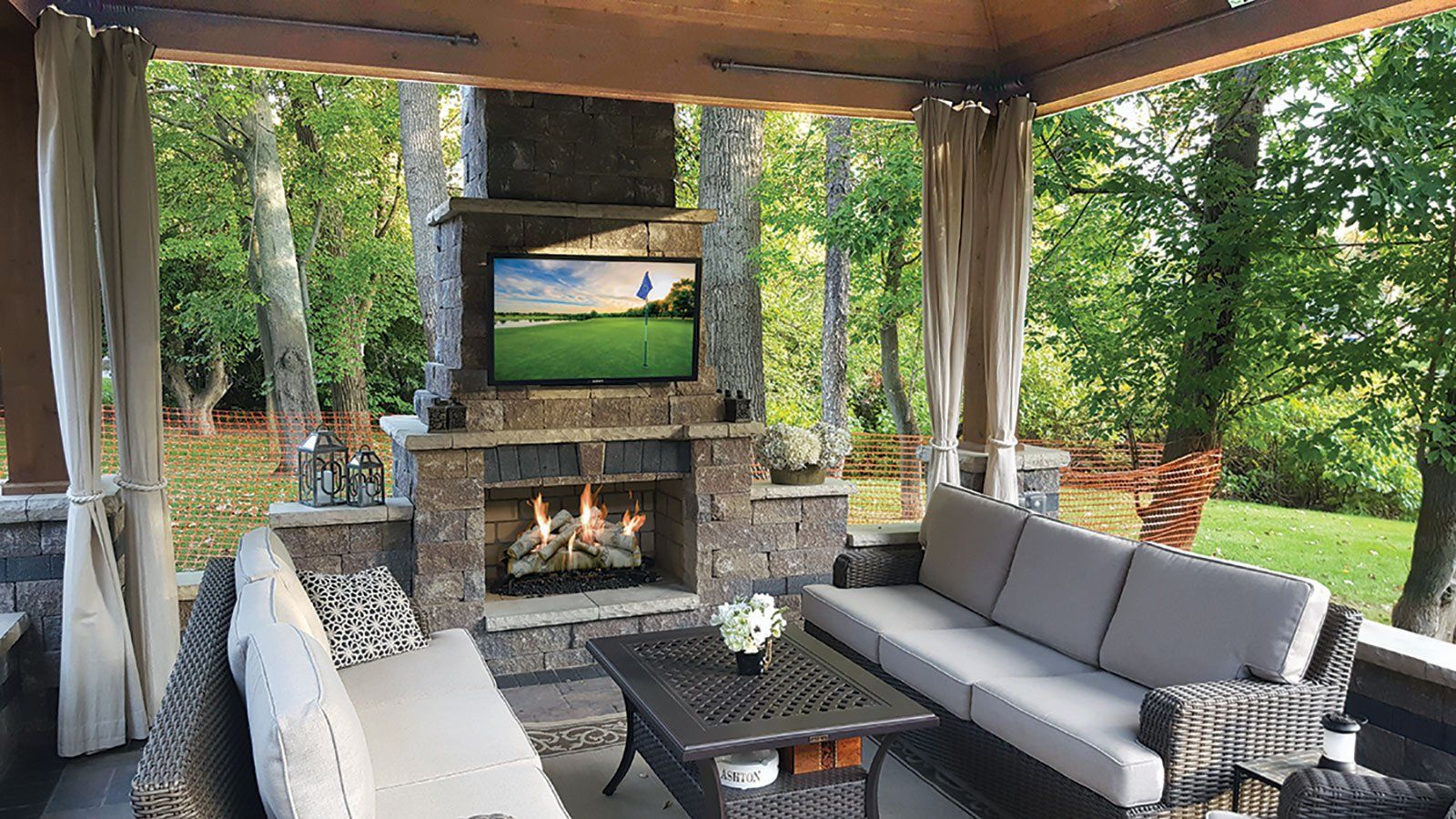 a living room with a couch , chairs , table , fireplace and television .