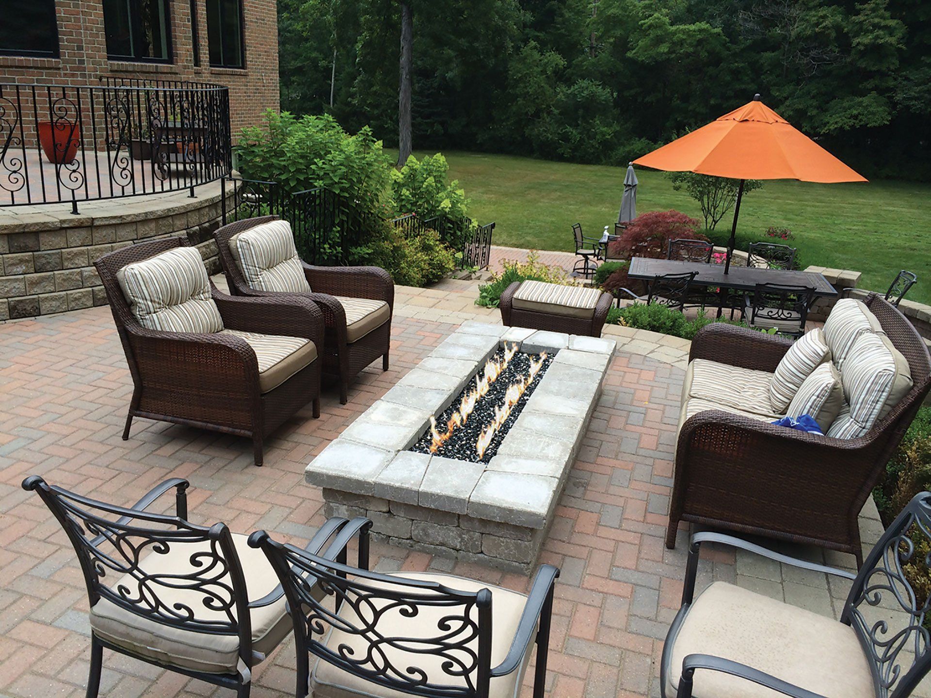 a patio with wicker furniture and a fire pit