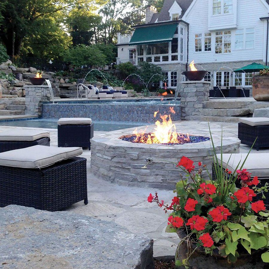 a fire pit in front of a large house