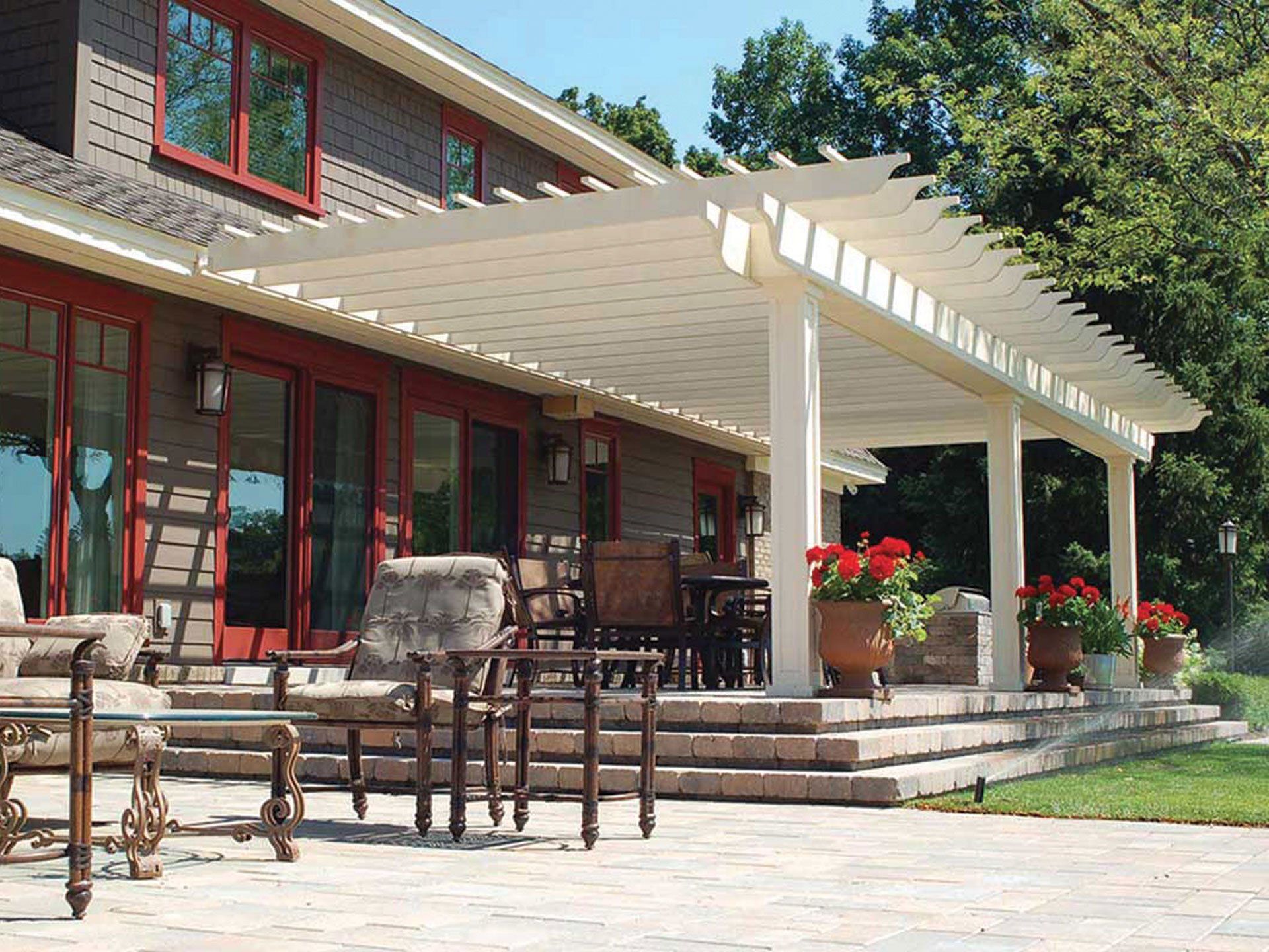 A large house with a pergola and patio furniture