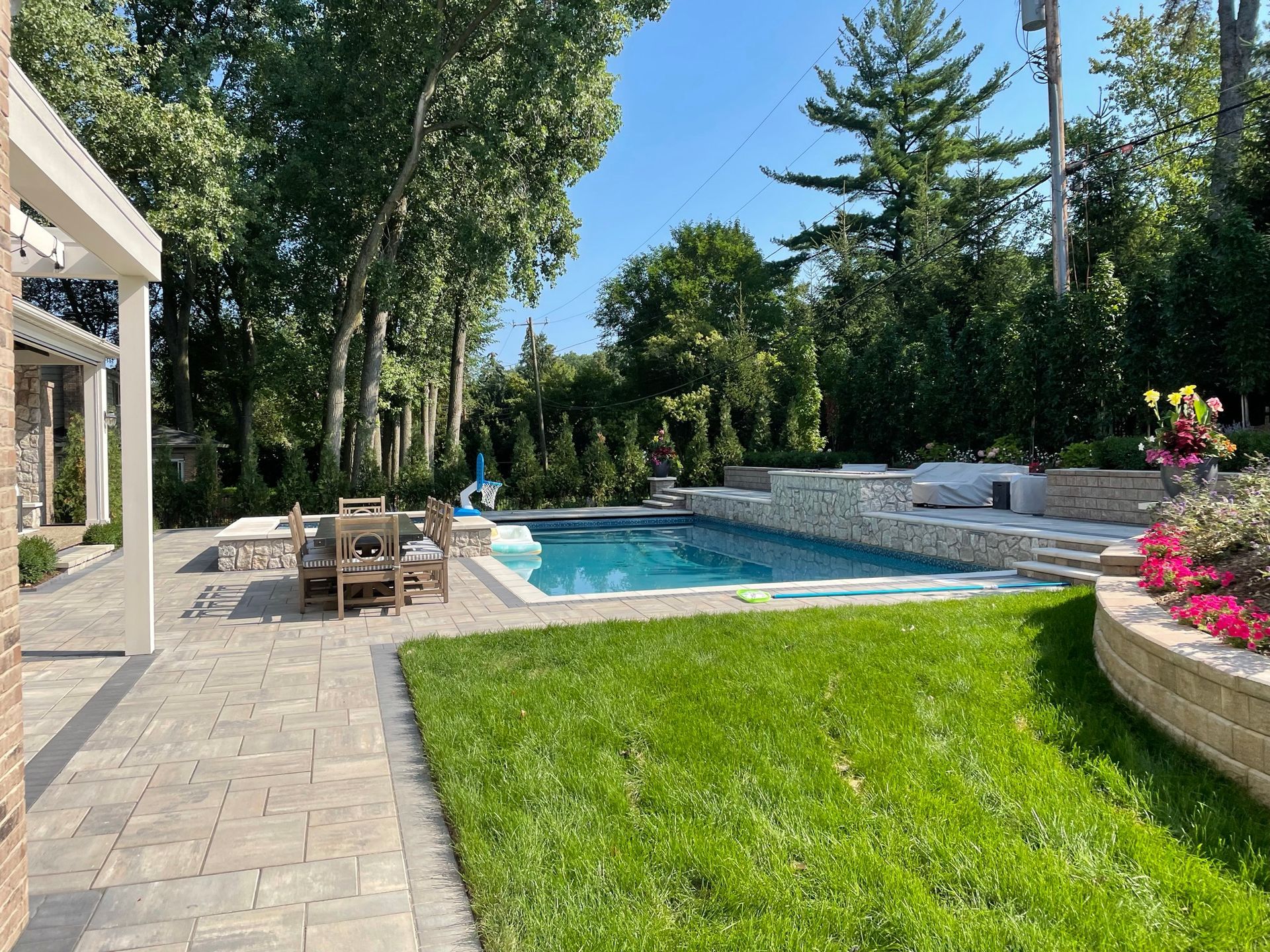 There is a large swimming pool in the backyard of a house.