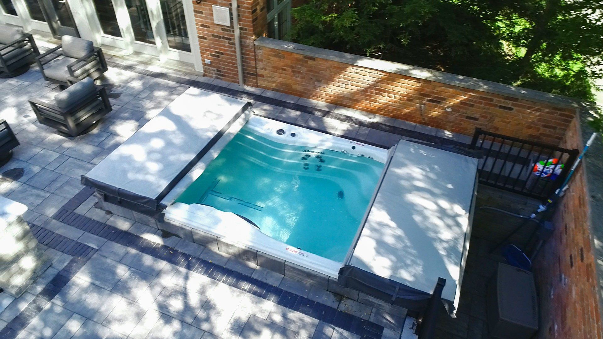 An aerial view of a small swimming pool in the backyard of a house.