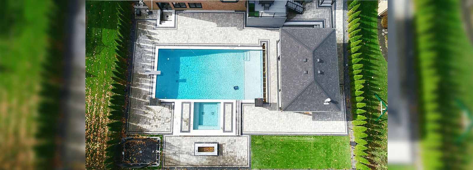 An aerial view of a house with a large swimming pool in the backyard.