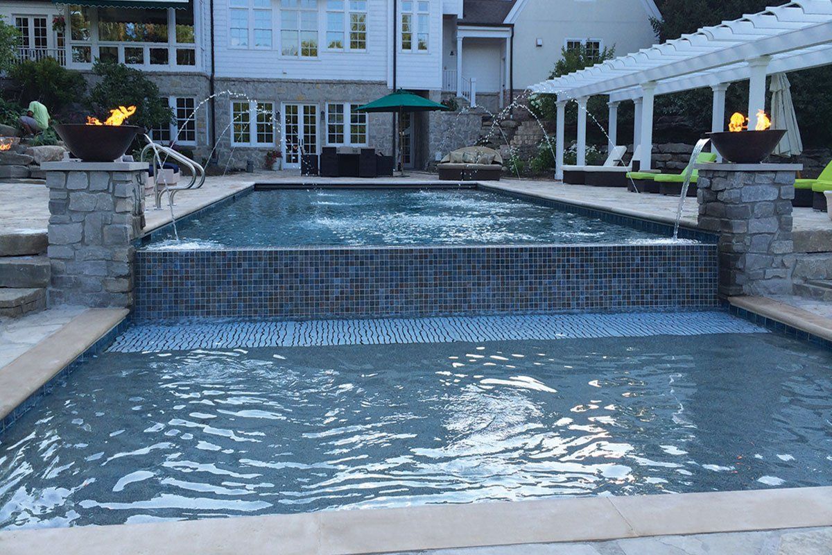 a large swimming pool with a waterfall in the middle of it .