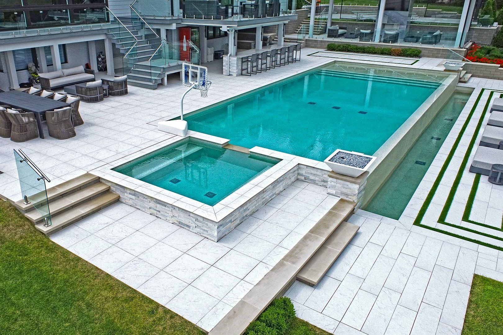 a large swimming pool with a hot tub in the backyard of a house .