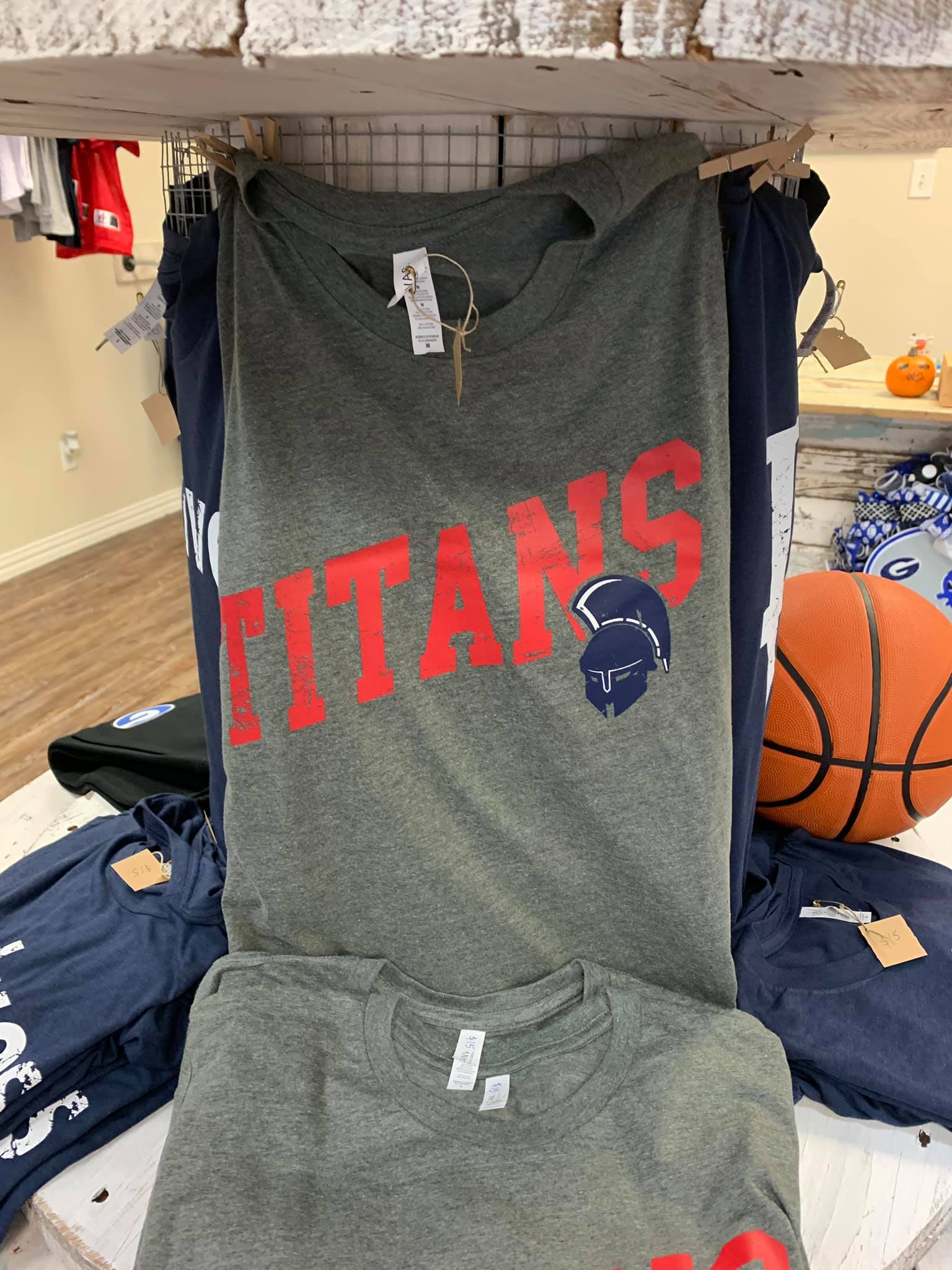 A t-shirt with the word titans on it is hanging on a rack.