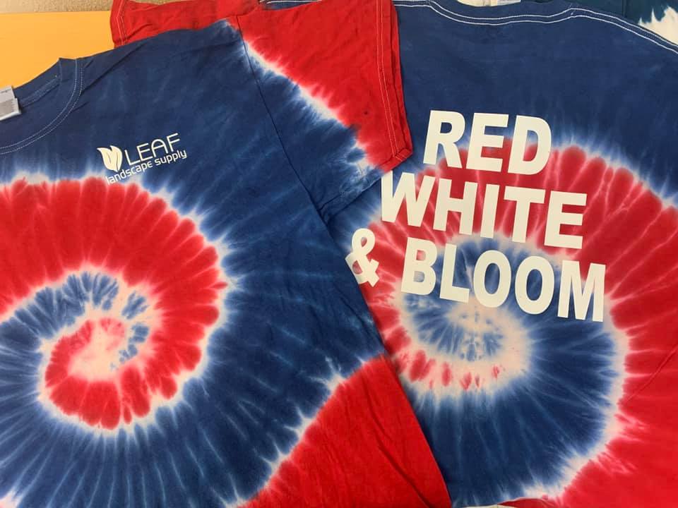 A red white and blue tie dye shirt that says red white and bloom.