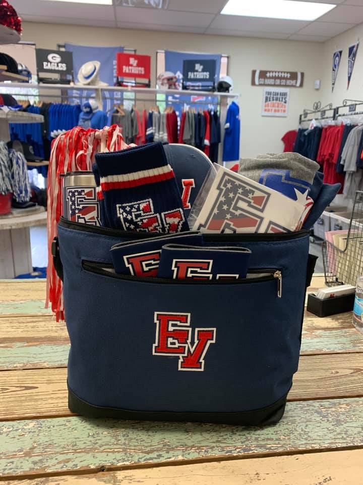A blue cooler with the letter e on it is sitting on a wooden table.