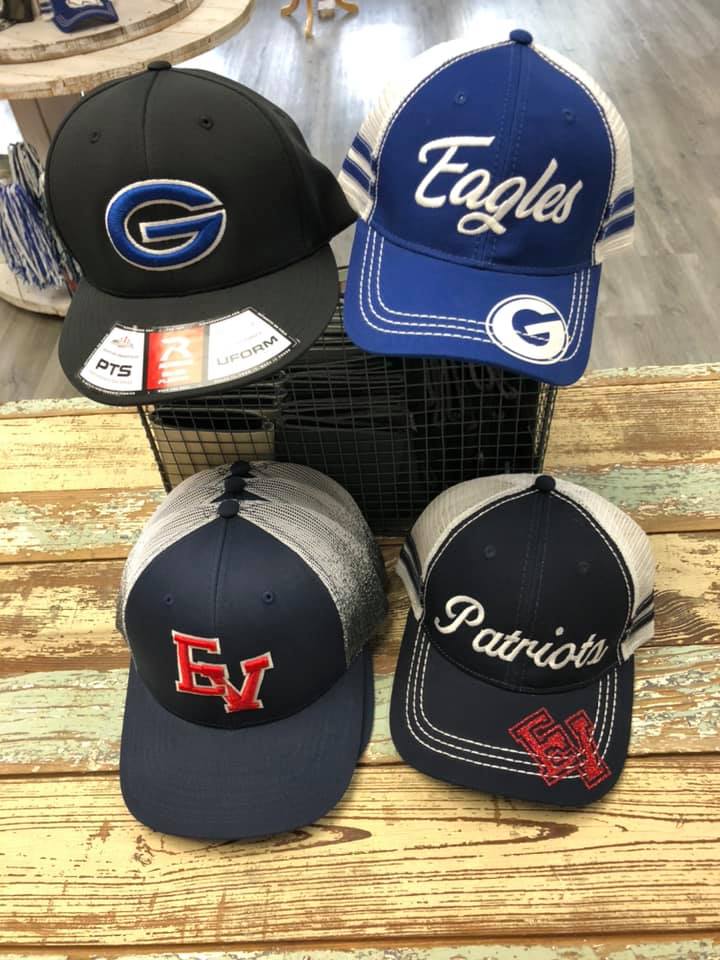 A bunch of hats are sitting on a wooden table.