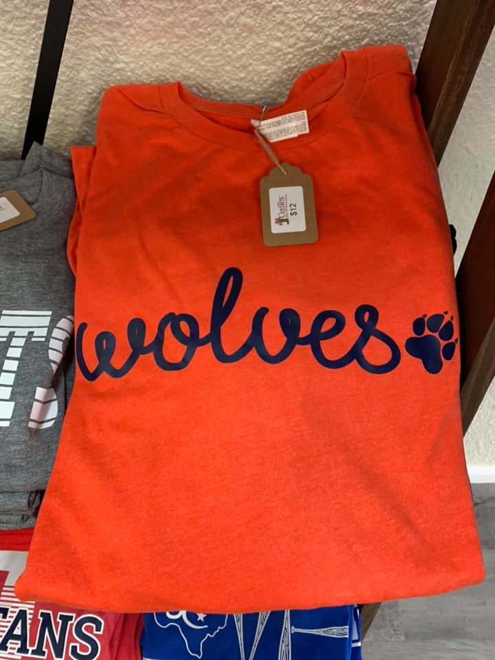 An orange t-shirt with the word wolves on it.