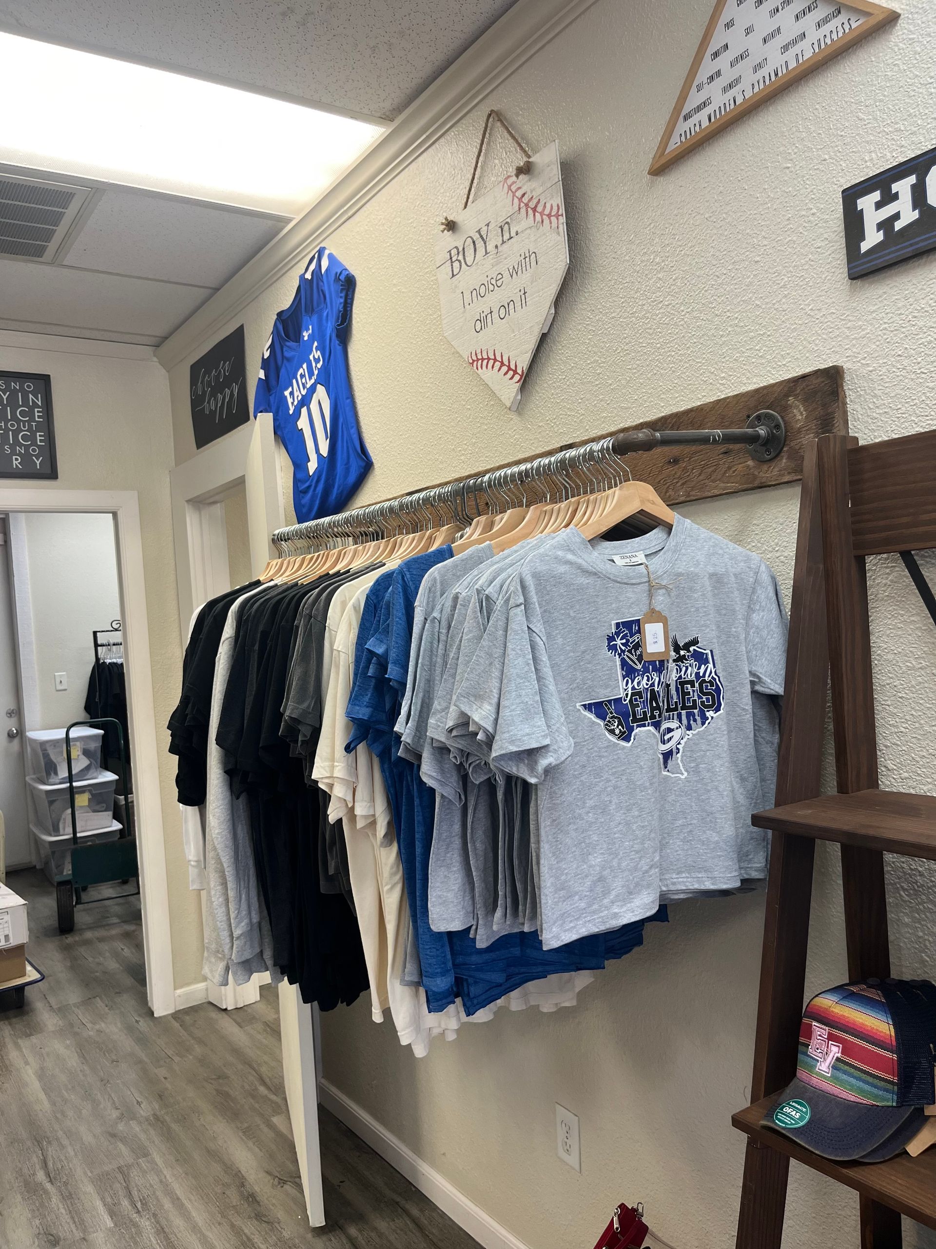 A bunch of shirts are hanging on a rack in a store.
