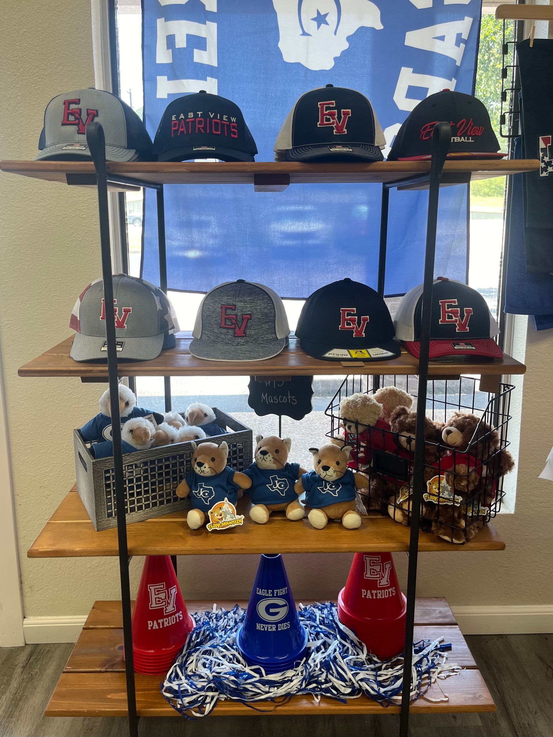 A shelf with hats and stuffed animals on it.