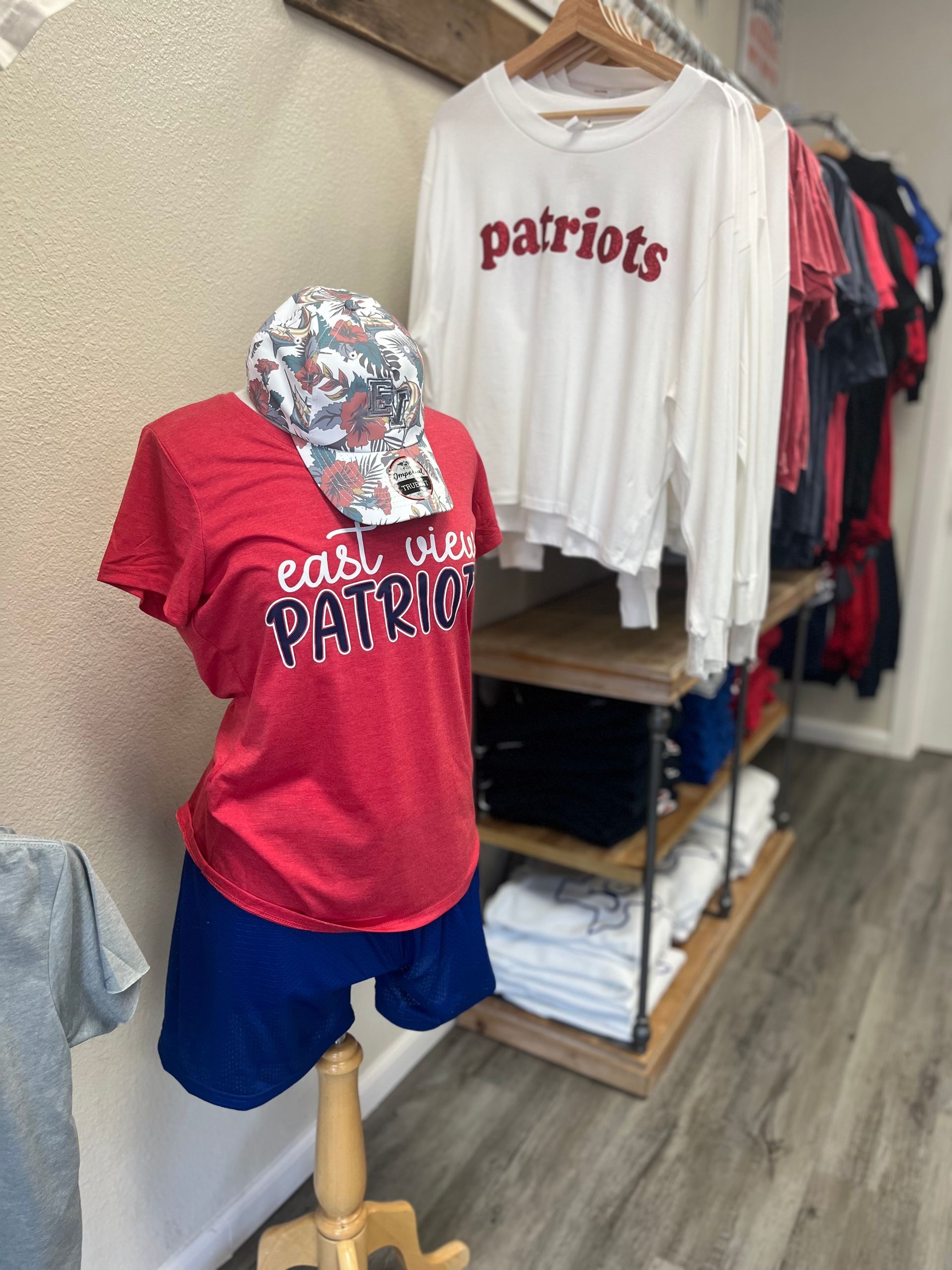 A red patriots shirt is on a mannequin in a store.