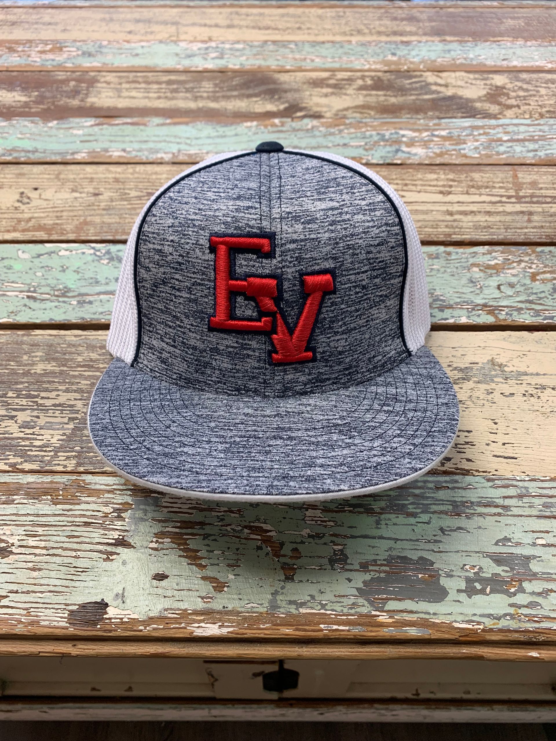 A baseball cap is sitting on top of a wooden table.