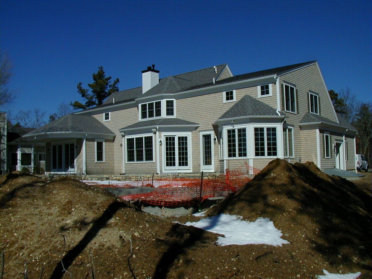 a large house is under construction with a pile of dirt in front of it