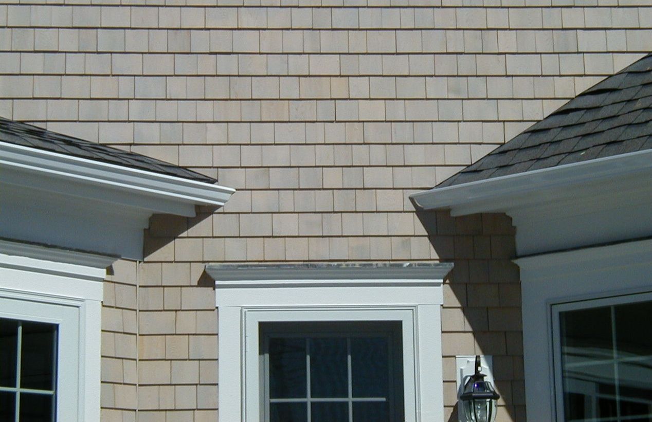 a house with two windows and a lamp on the side