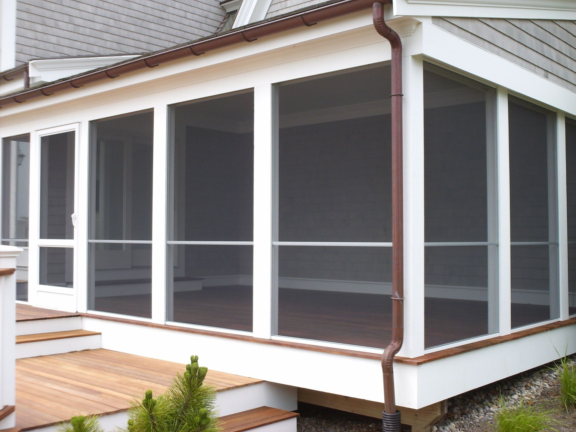 a screened in porch on the side of a house