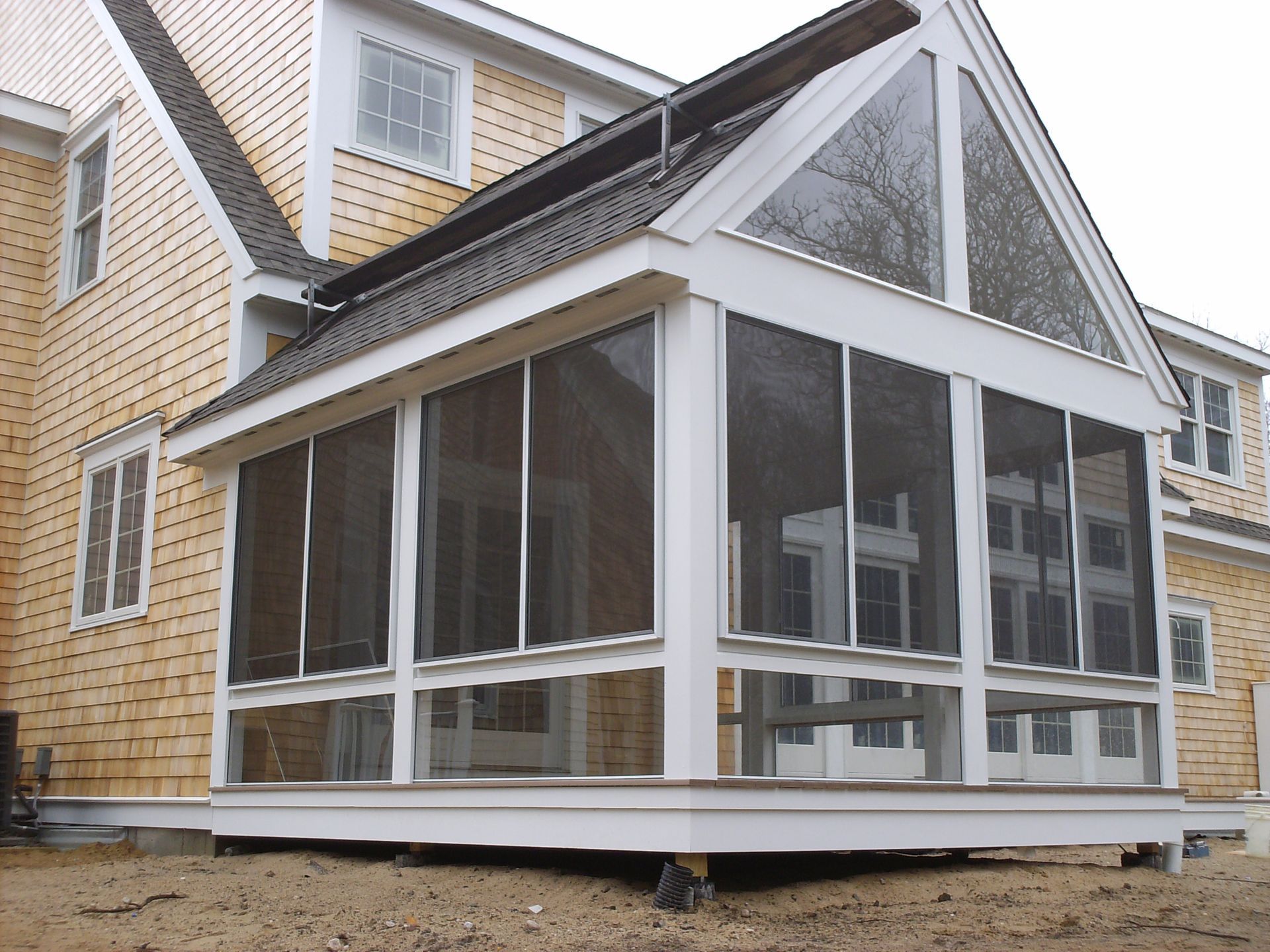 a screened in porch in front of a house