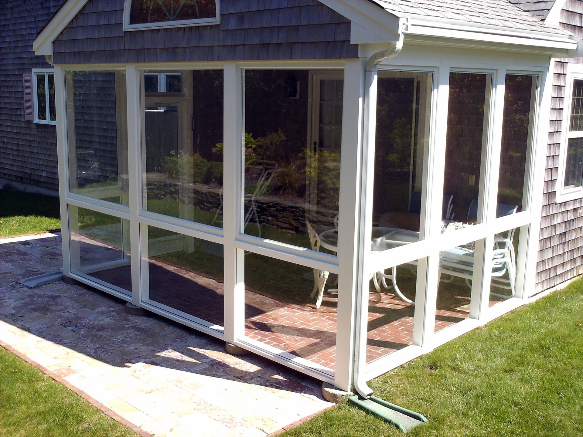 a screened in porch in the backyard of a house