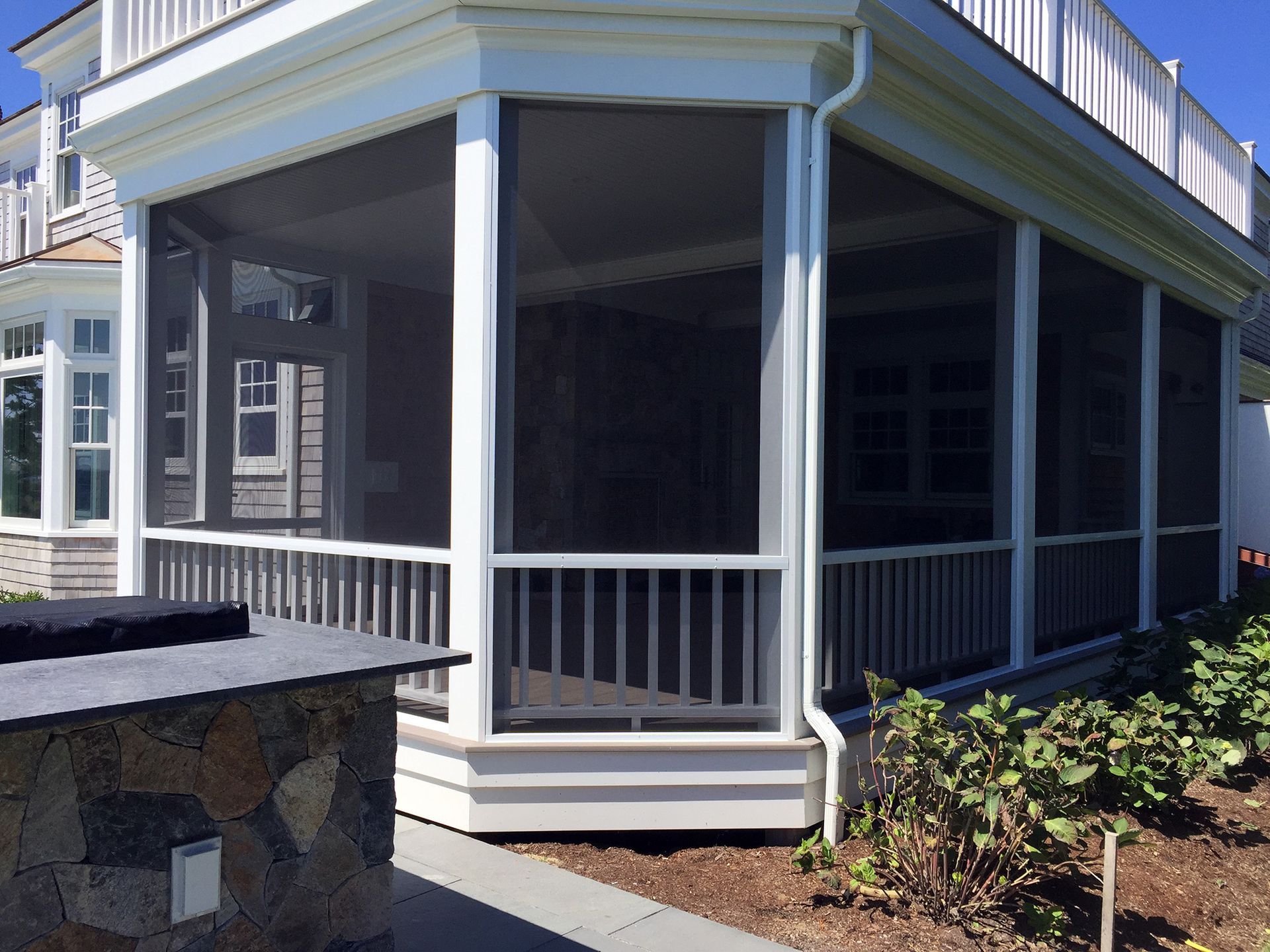 a screened in porch on the side of a house