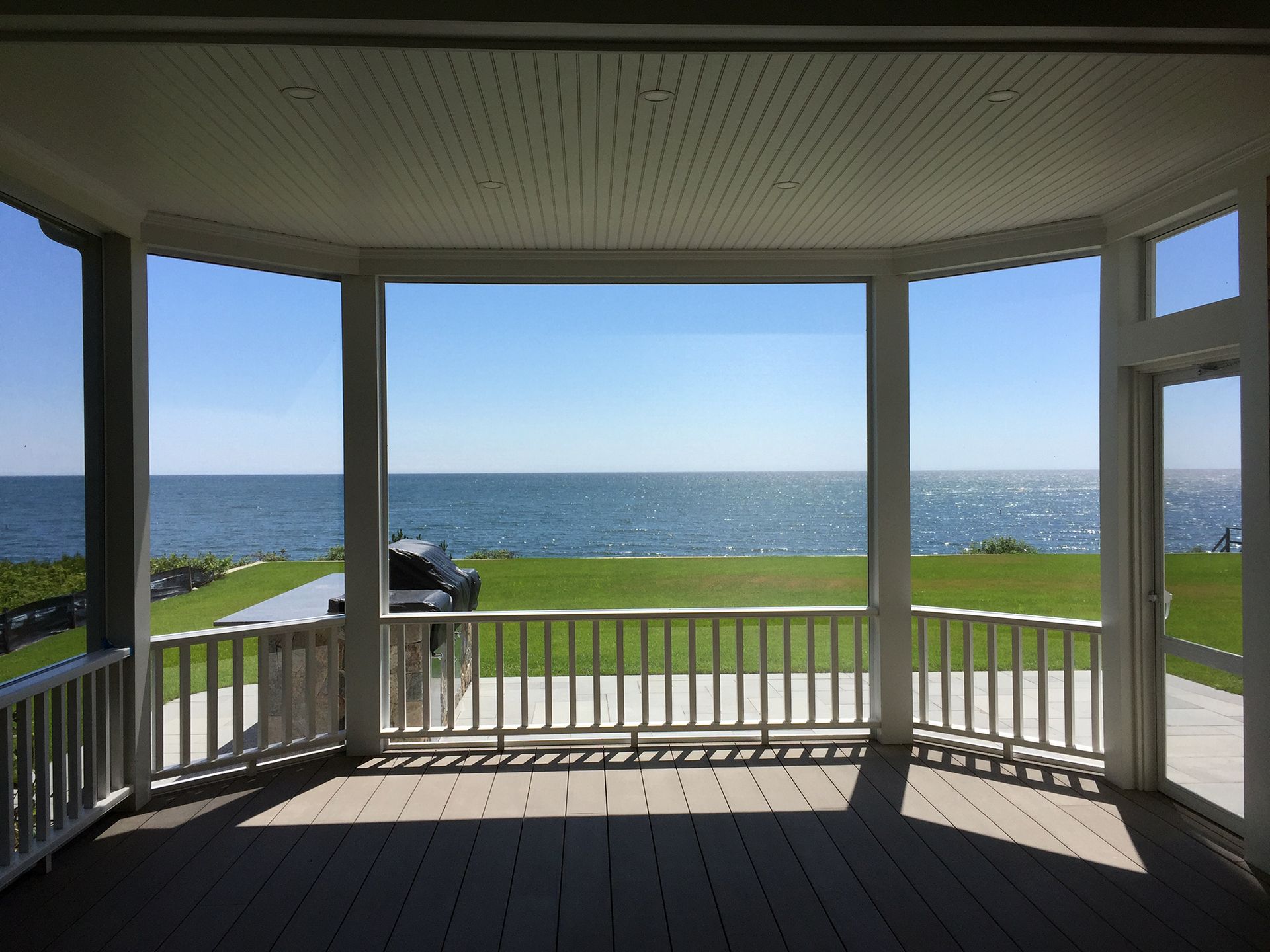 a screened in porch with a view of the ocean