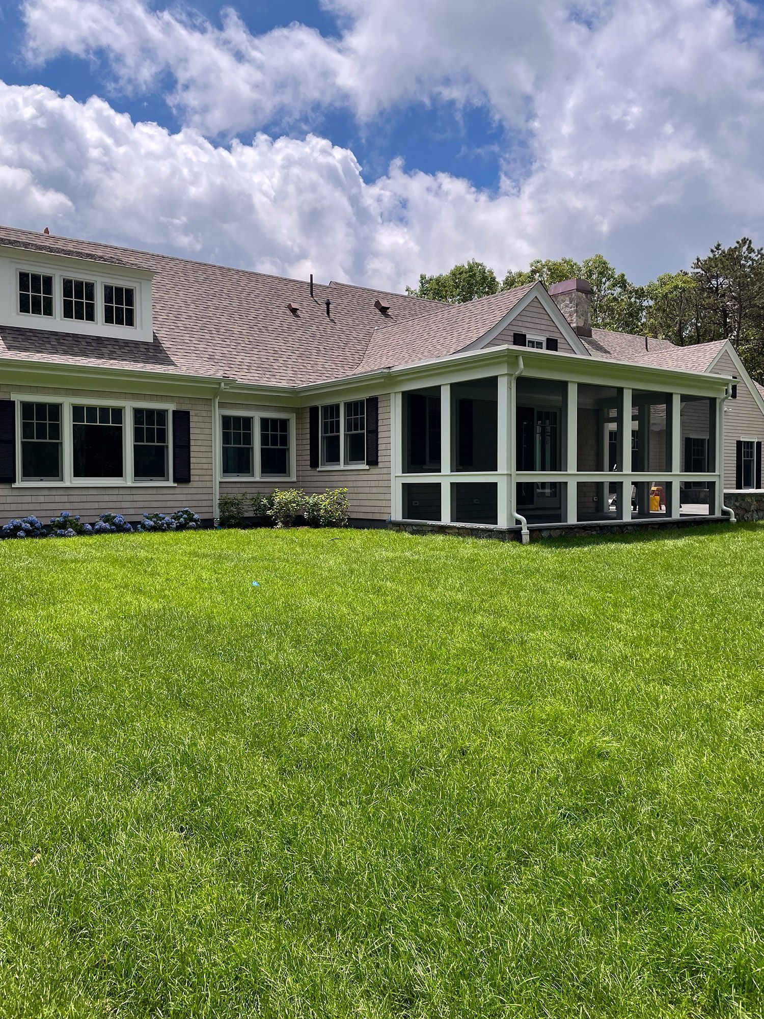 a large house with a screened in porch and a large lawn in front of it