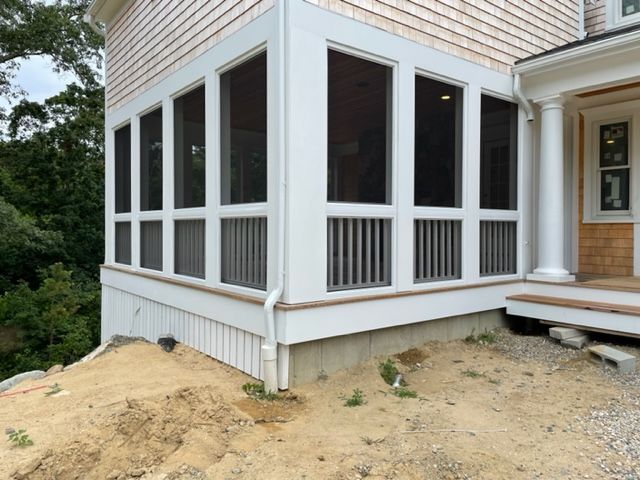 a screened in porch on the side of a house