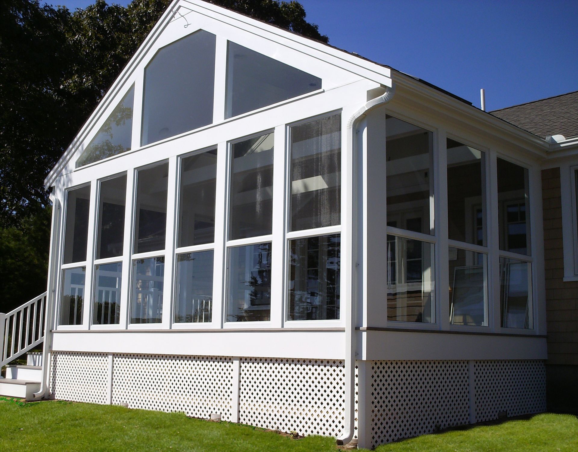 a house with a screened in porch with lots of windows