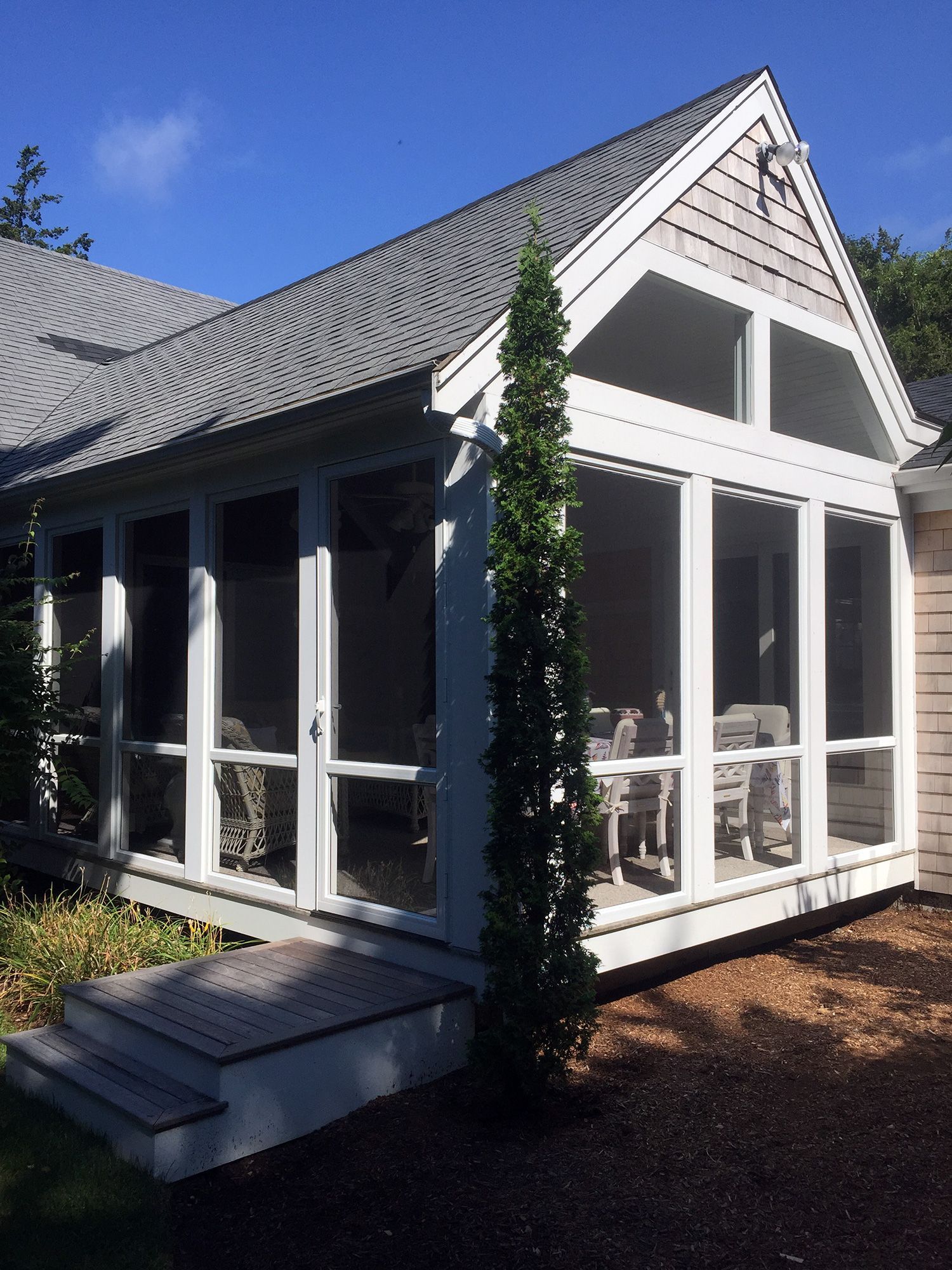 a screened in porch on the side of a house