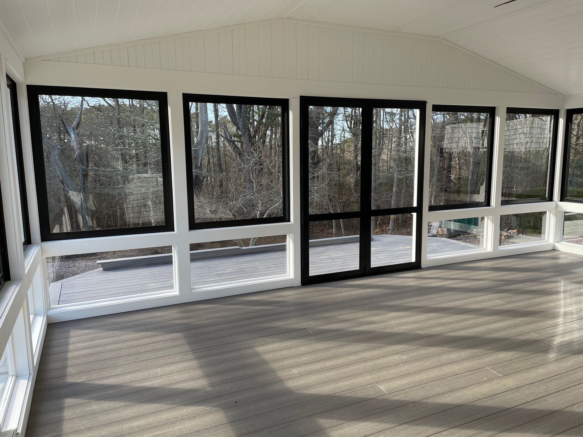 an empty room with a lot of windows and a wooden floor