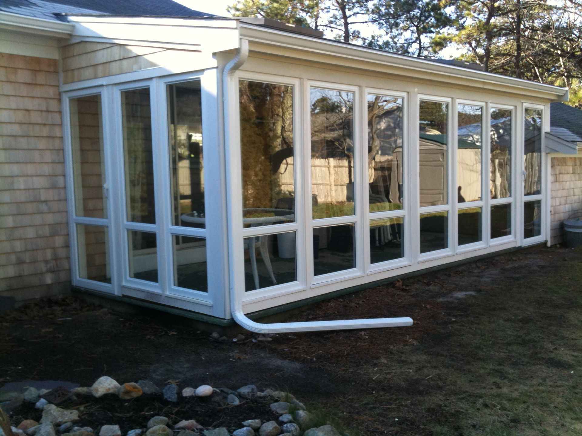 a sunroom with a lot of windows on the side of a house