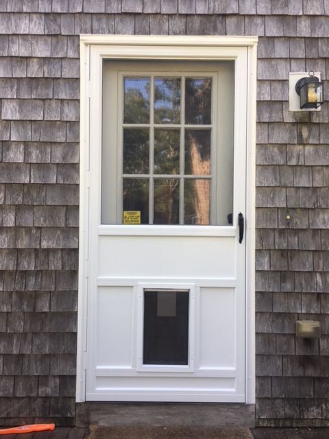 a white door with a cat door on the side of it