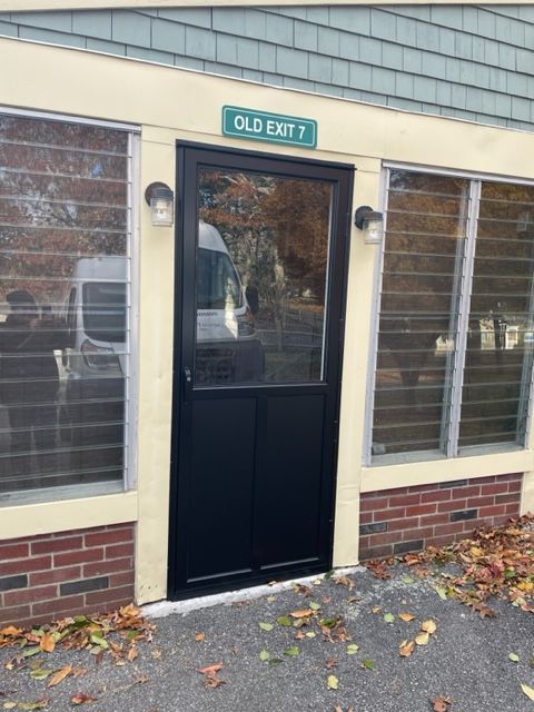 a black door with a green sign above it that says old exit 7