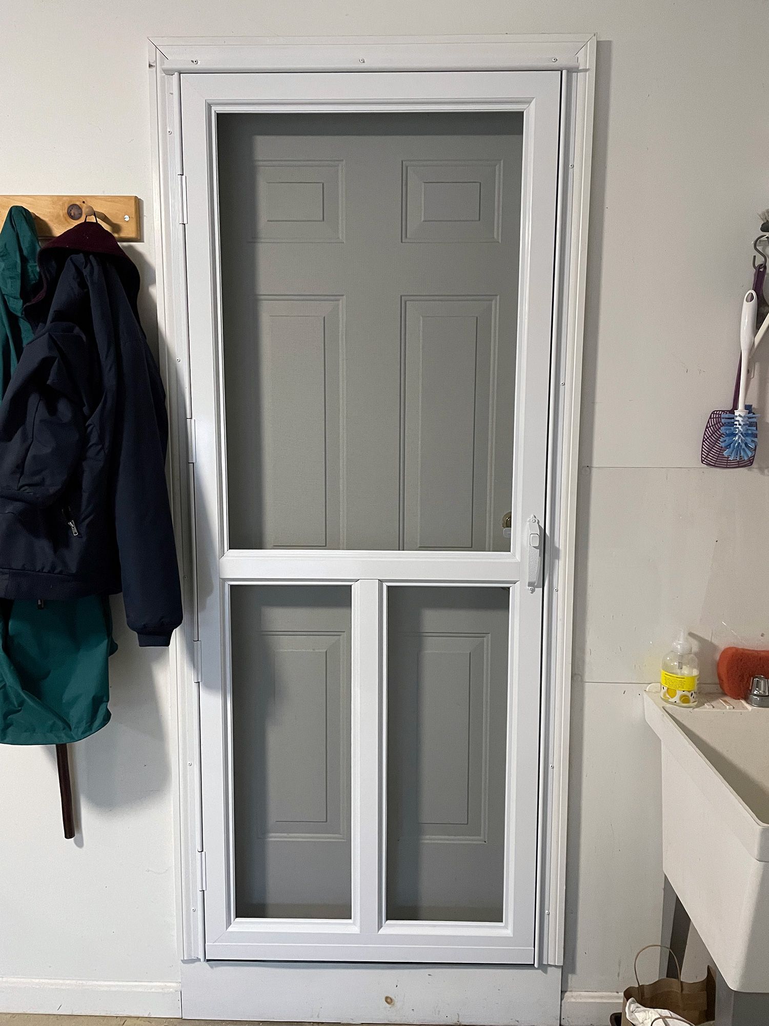 a screen door is sitting in a room next to a sink