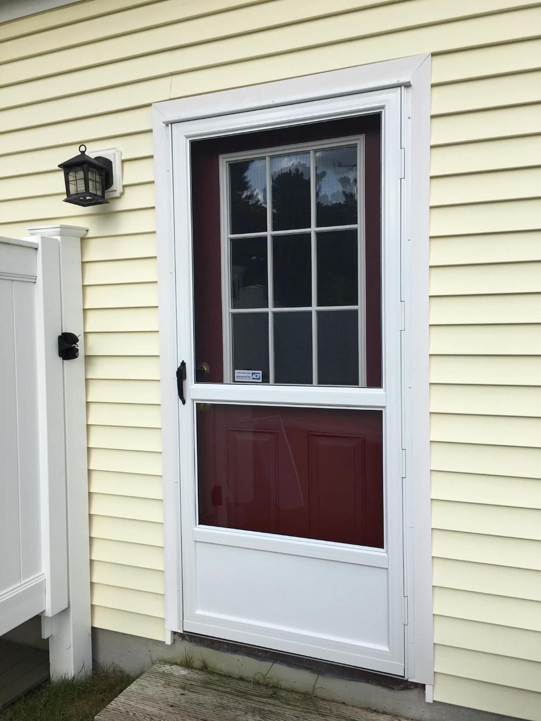 a red door with a white frame is on the side of a house