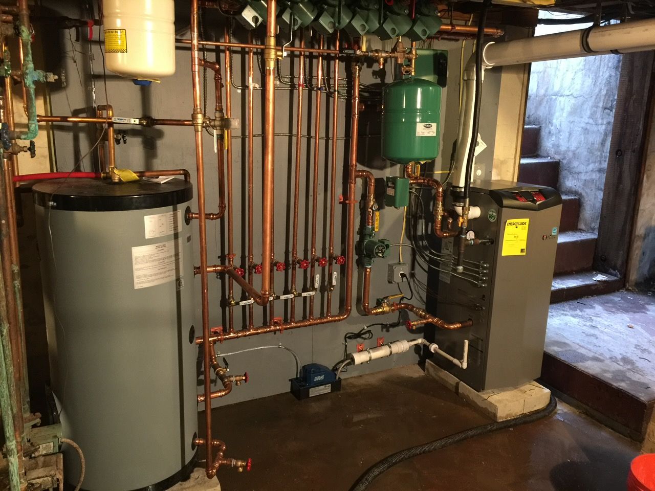 Copper plumbing pipes with several brass shutoff valves in a utility wall