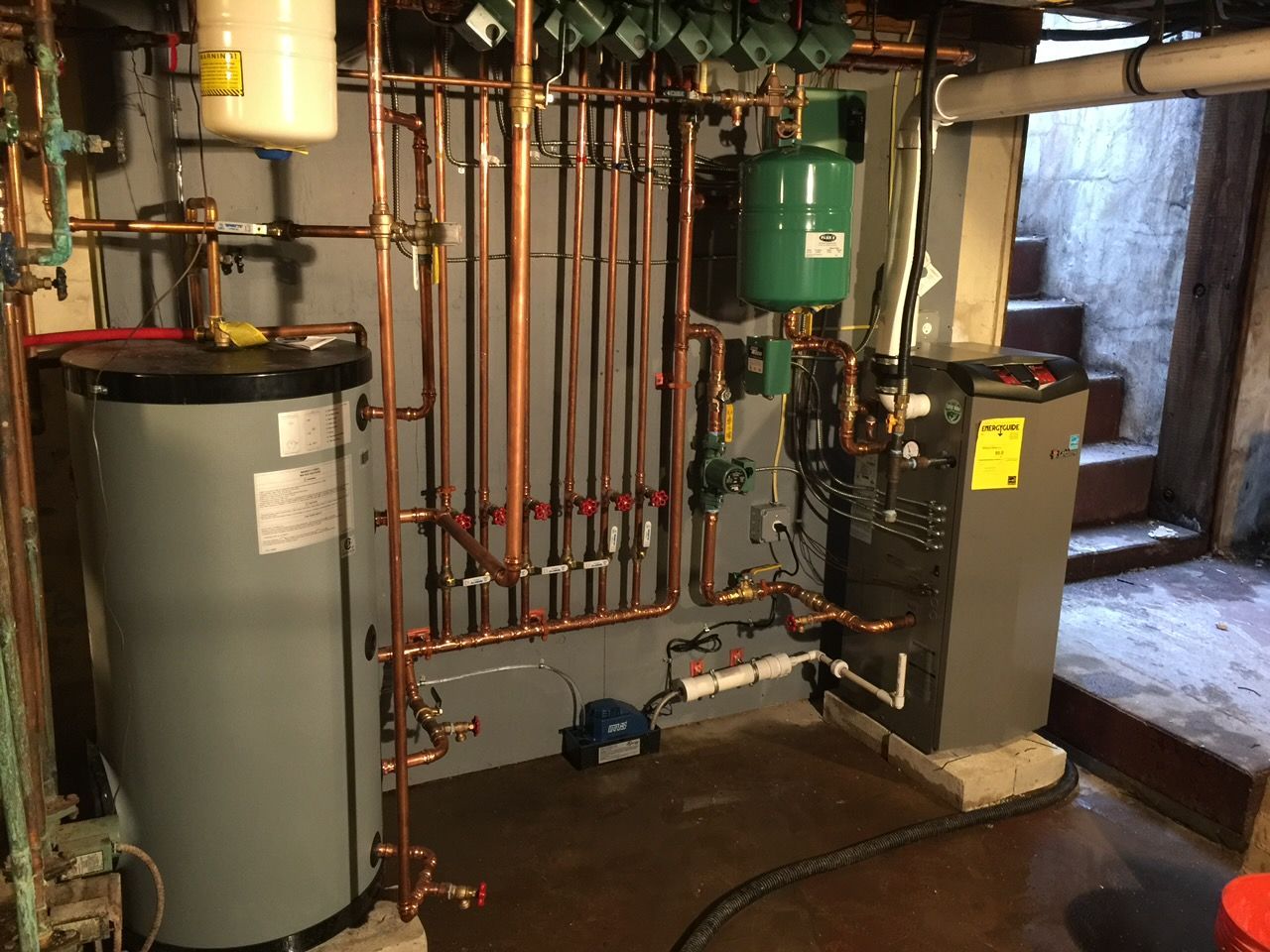 Basement HVAC furnace and ductwork beneath exposed wooden beams and insulation