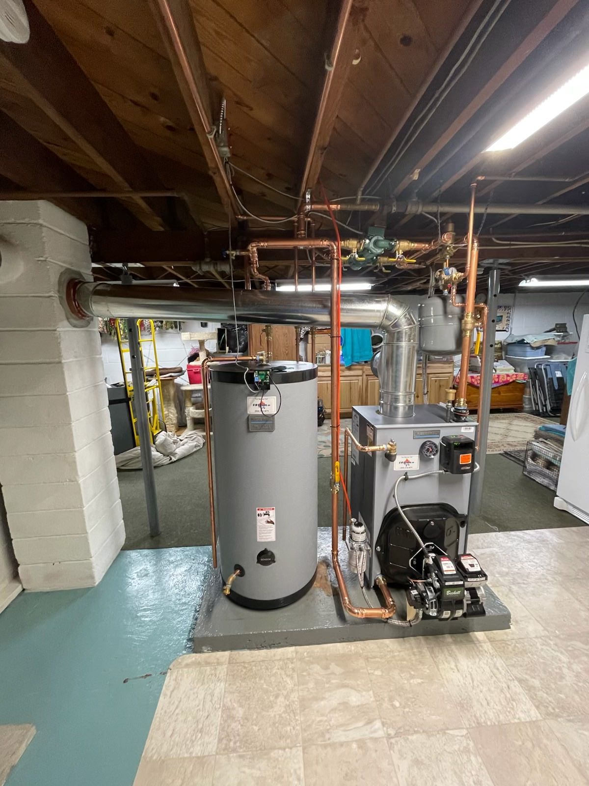 Basement utility room with a water heater, furnace, exposed beams, and ductwork.