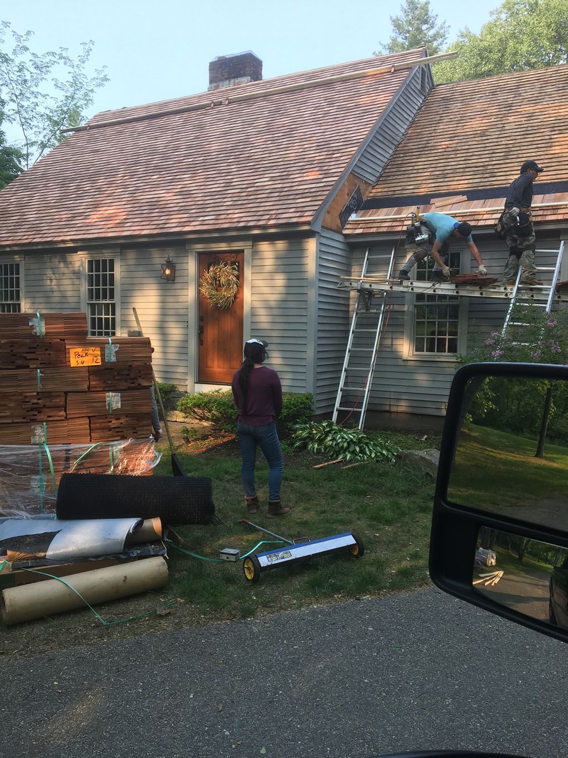 A group of people are working on the roof of a house