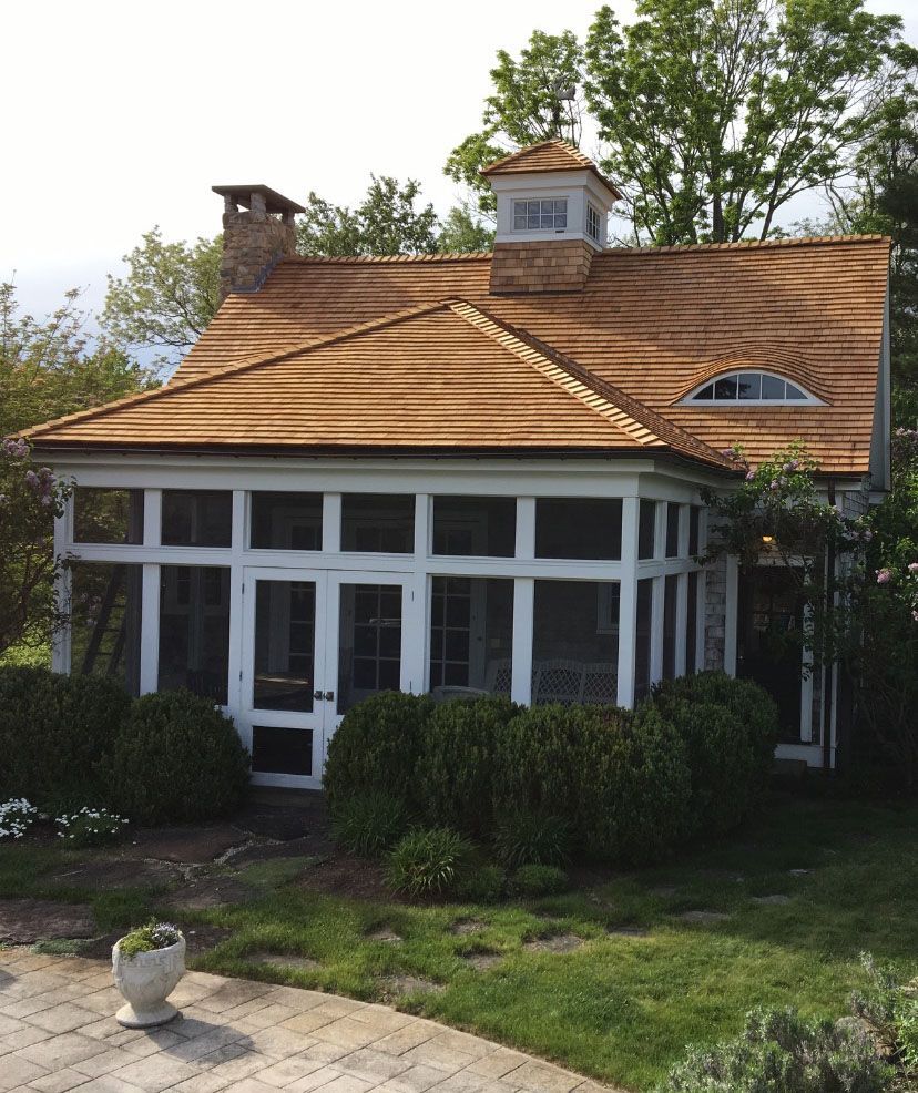 A house with a screened in porch and a shingle roof