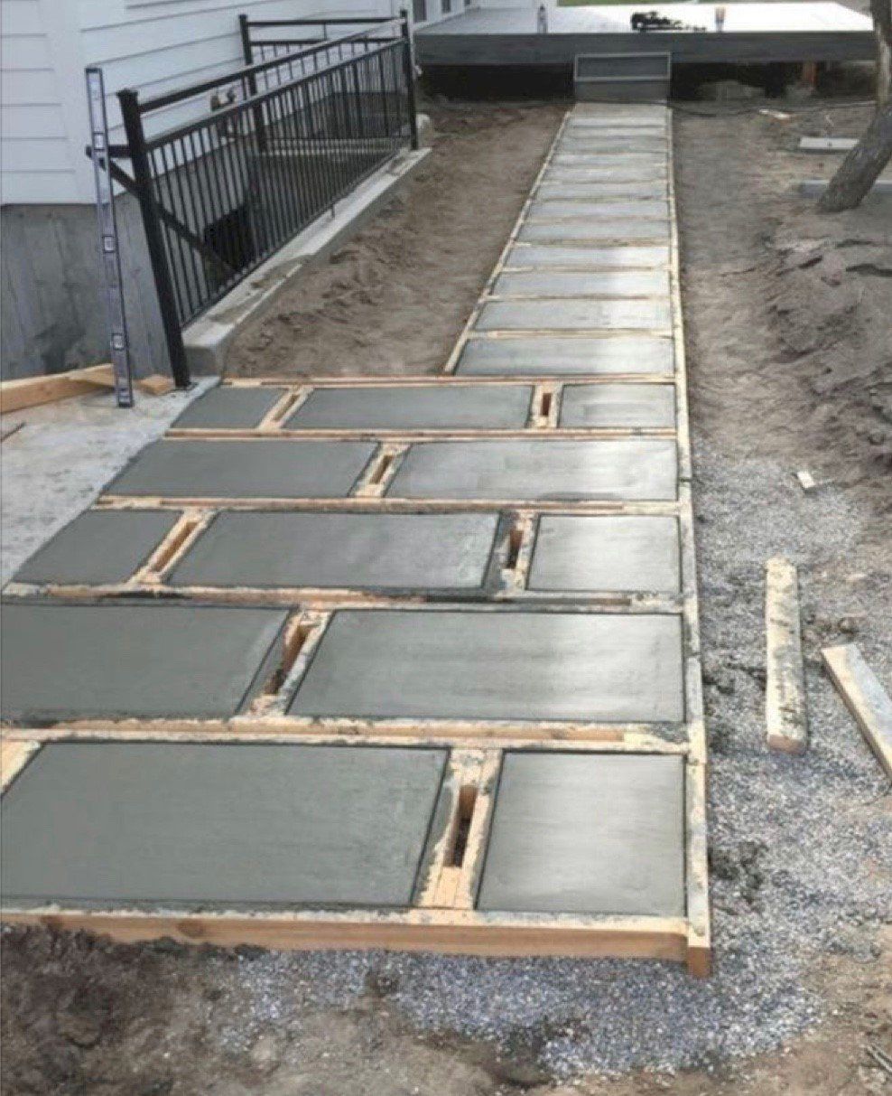 A concrete walkway is being built in front of a house.