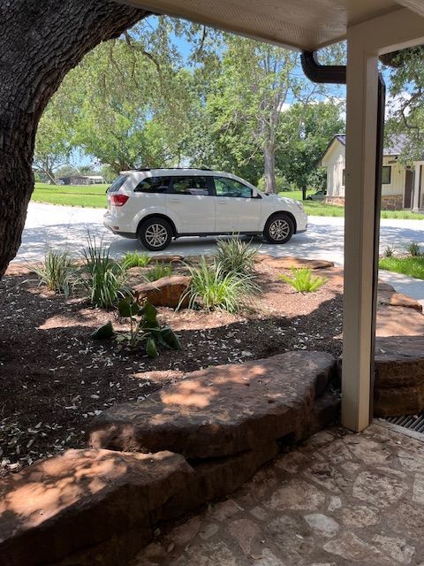 A white suv is parked under a covered porch.