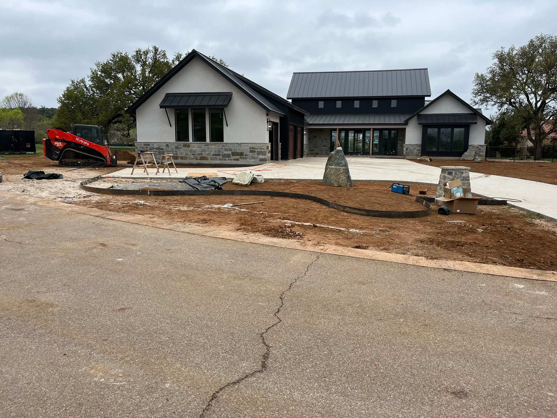 A large house is being built in the middle of a dirt road.