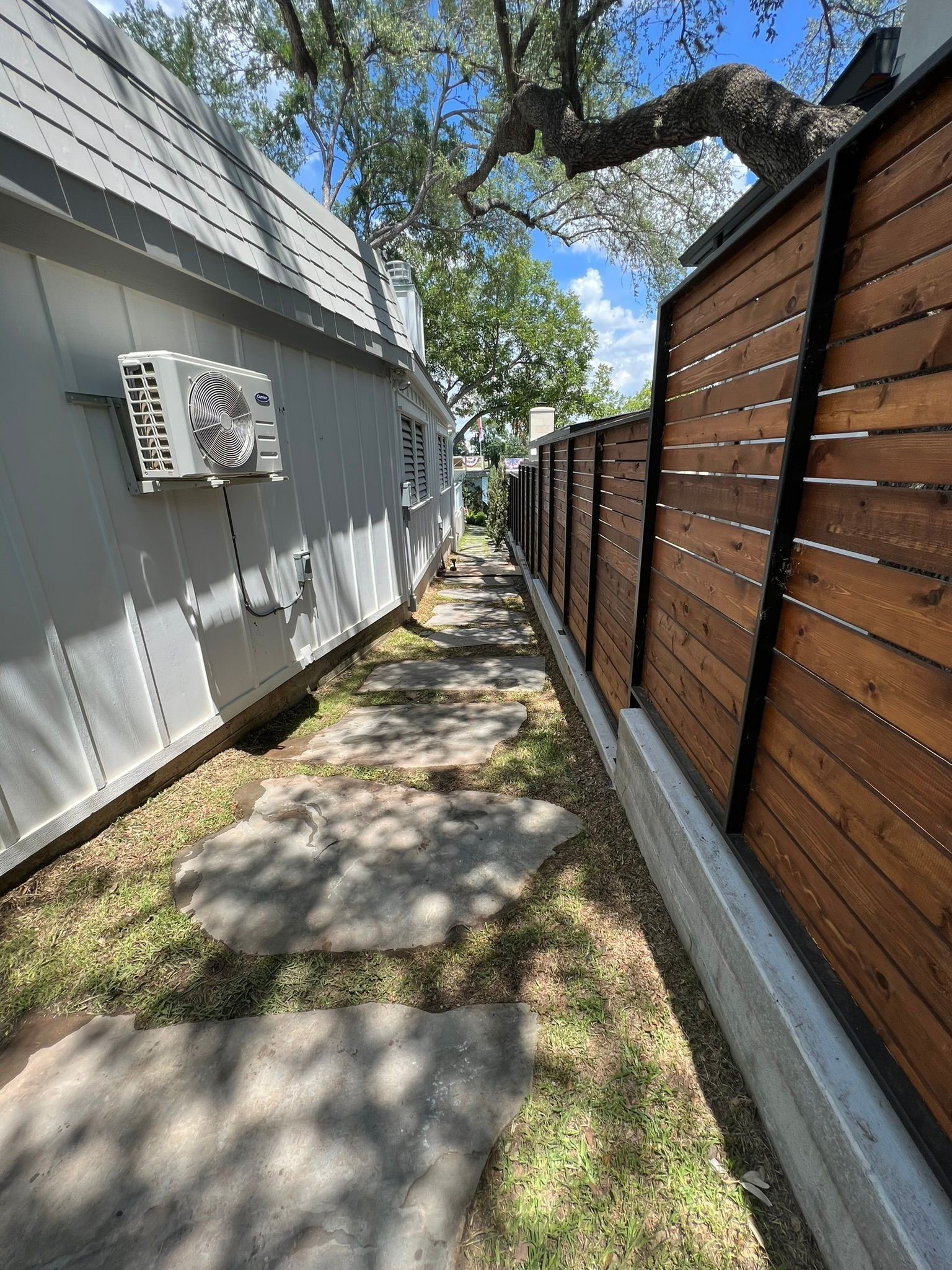 A wooden fence along a sidewalk next to a building.