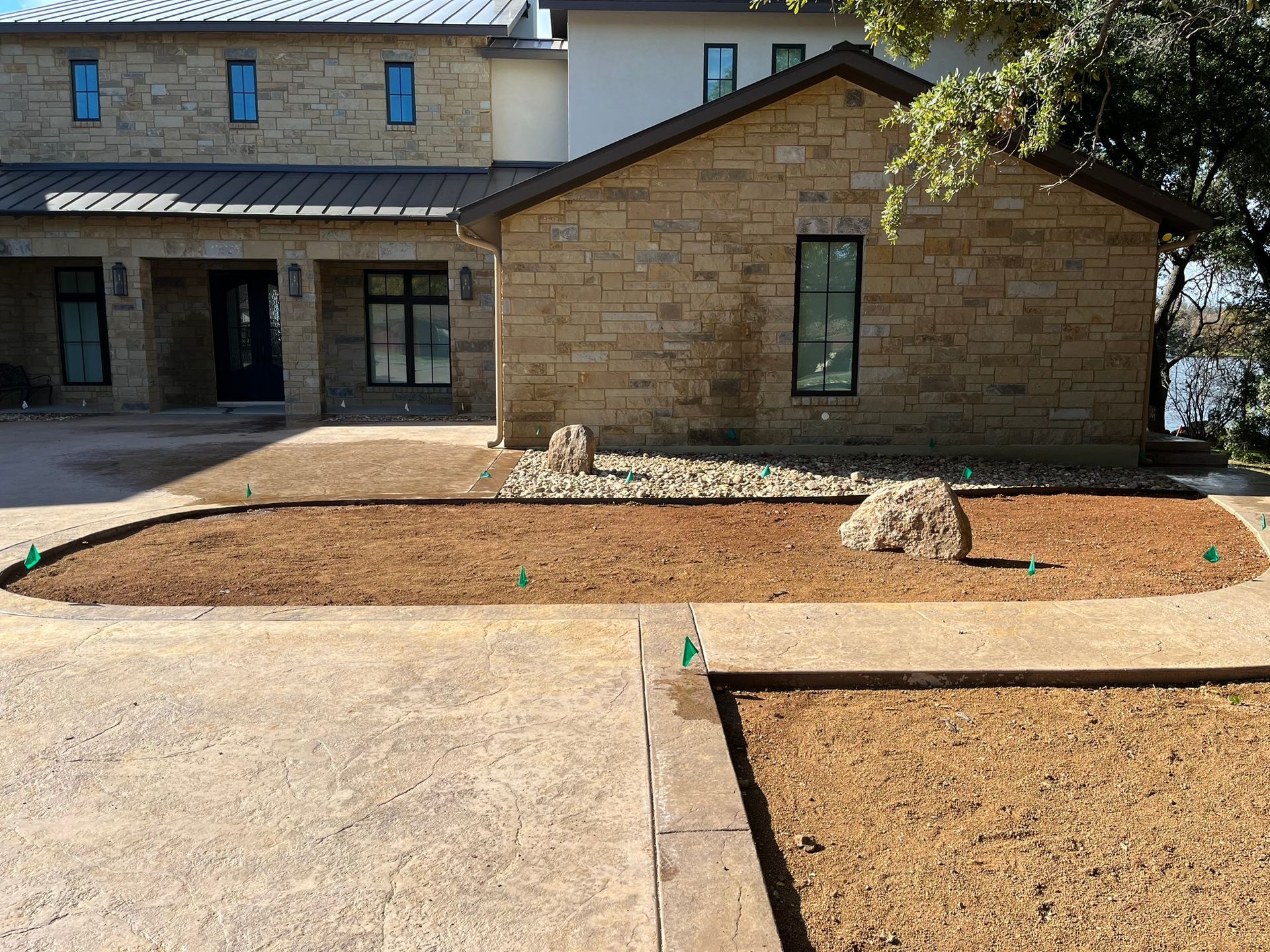 A large brick house with a large driveway in front of it.