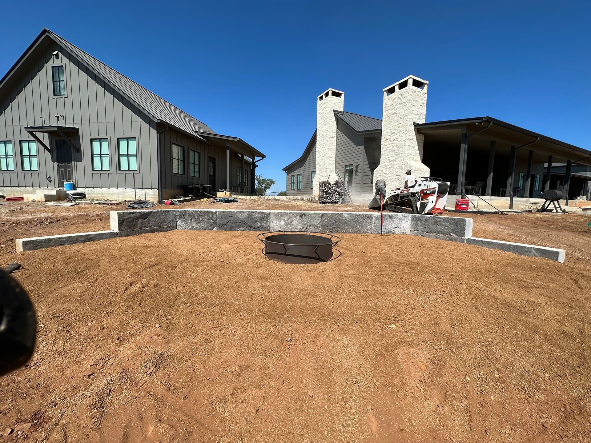A large house with a fire pit in front of it.