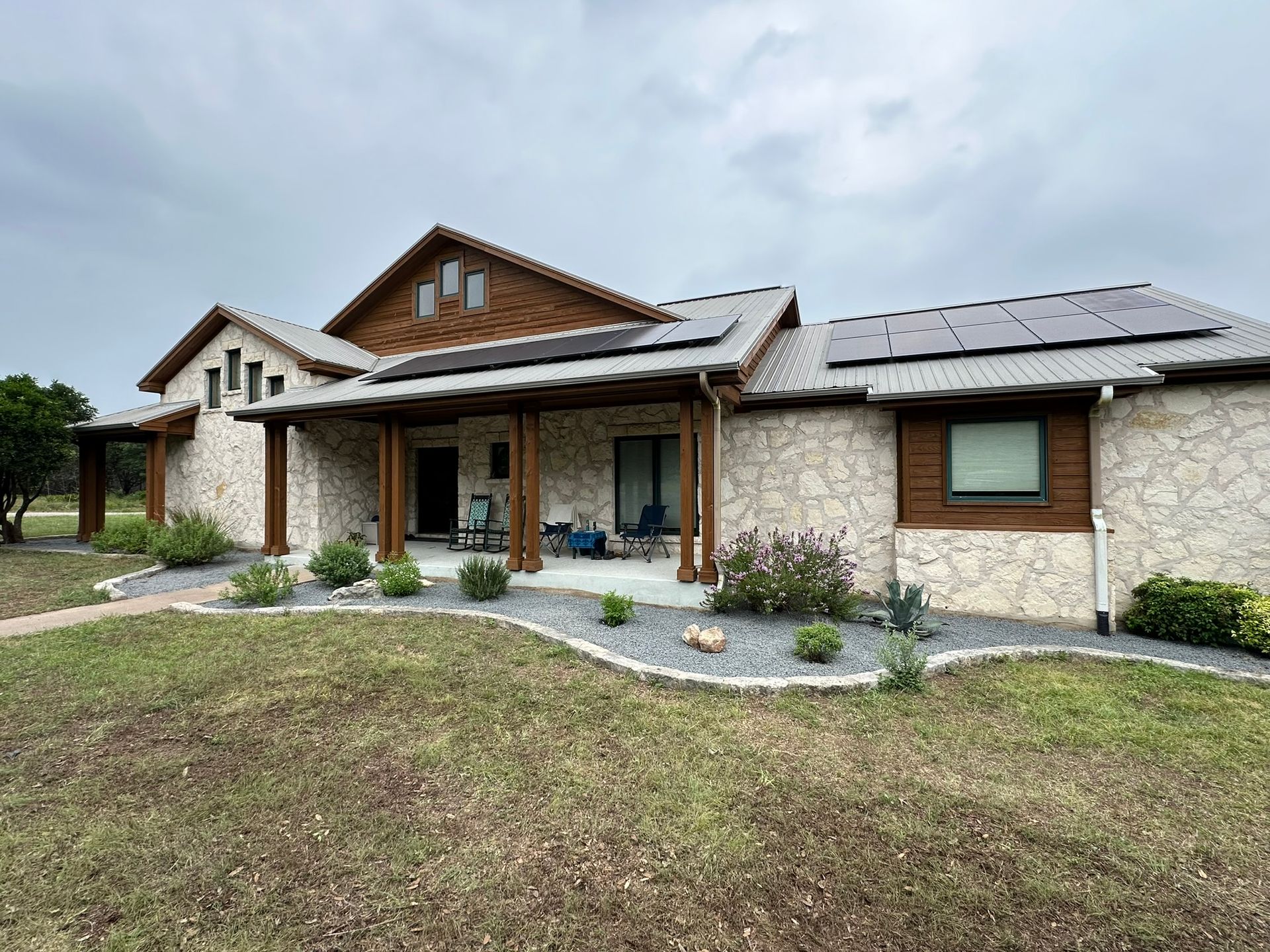 A large house with a porch and solar panels on the roof.