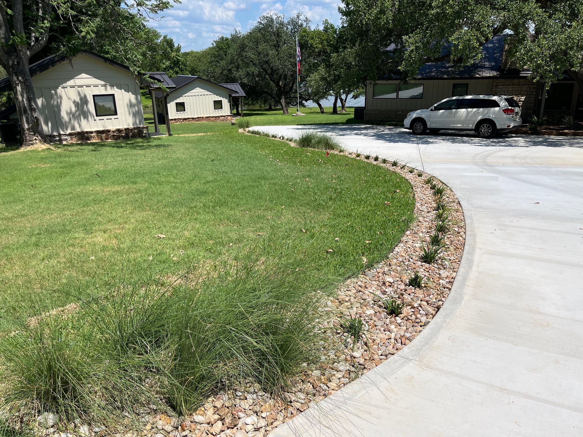 A white car is parked in a driveway next to a house.