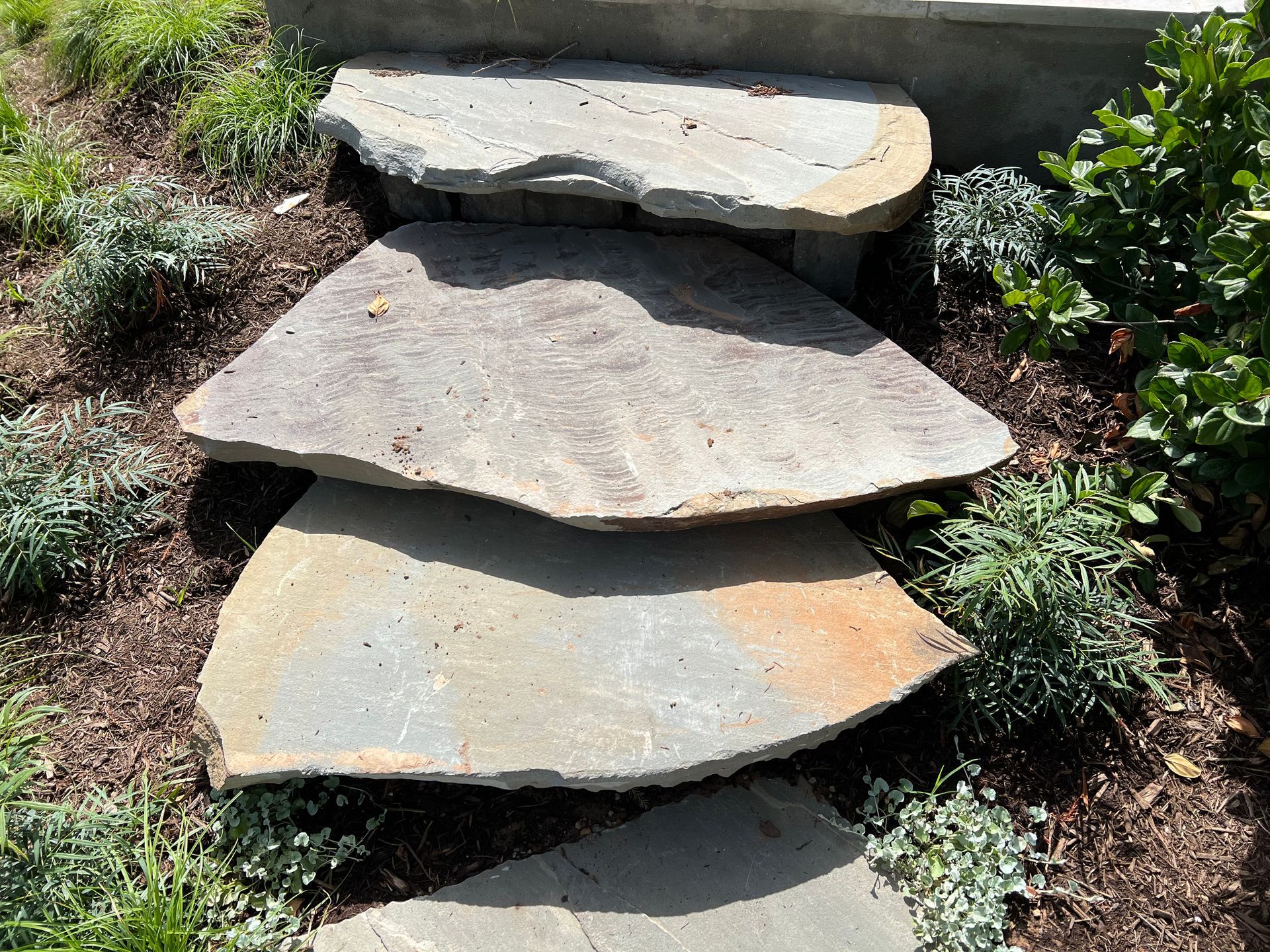 A set of stone steps going up a hill in a garden